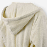 Close-up of the back of a cream terry cotton bathrobe showing the hood detail.
