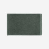 Dark green cotton bath sheet in horizontal orientation with woven border bands, shown against a white background.