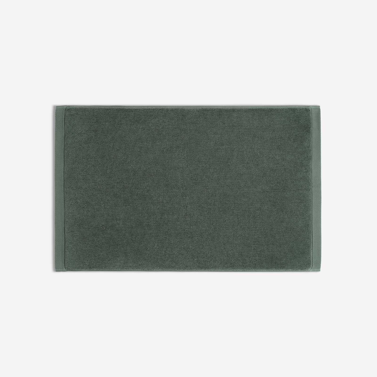 Dark green cotton bath sheet in horizontal orientation with woven border bands, shown against a white background.