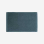 Teal cotton bath sheet in horizontal orientation with woven border bands, shown against a white background.