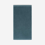 Teal cotton bath sheet in vertical orientation with woven border bands, shown against a white background.