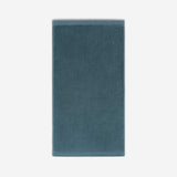Teal cotton bath sheet in vertical orientation with woven border bands, shown against a white background.
