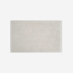 Light beige cotton bath sheet in horizontal orientation with woven border bands, shown against a white background.