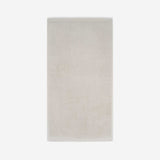 Light beige cotton bath sheet in vertical orientation with woven border bands, shown against a white background.