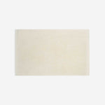 Cream cotton bath sheet in horizontal orientation with woven border bands, shown against a white background.