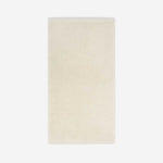 Cream cotton bath sheet in vertical orientation with woven border bands, shown against a white background.