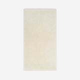 Cream cotton bath sheet in vertical orientation with woven border bands, shown against a white background.