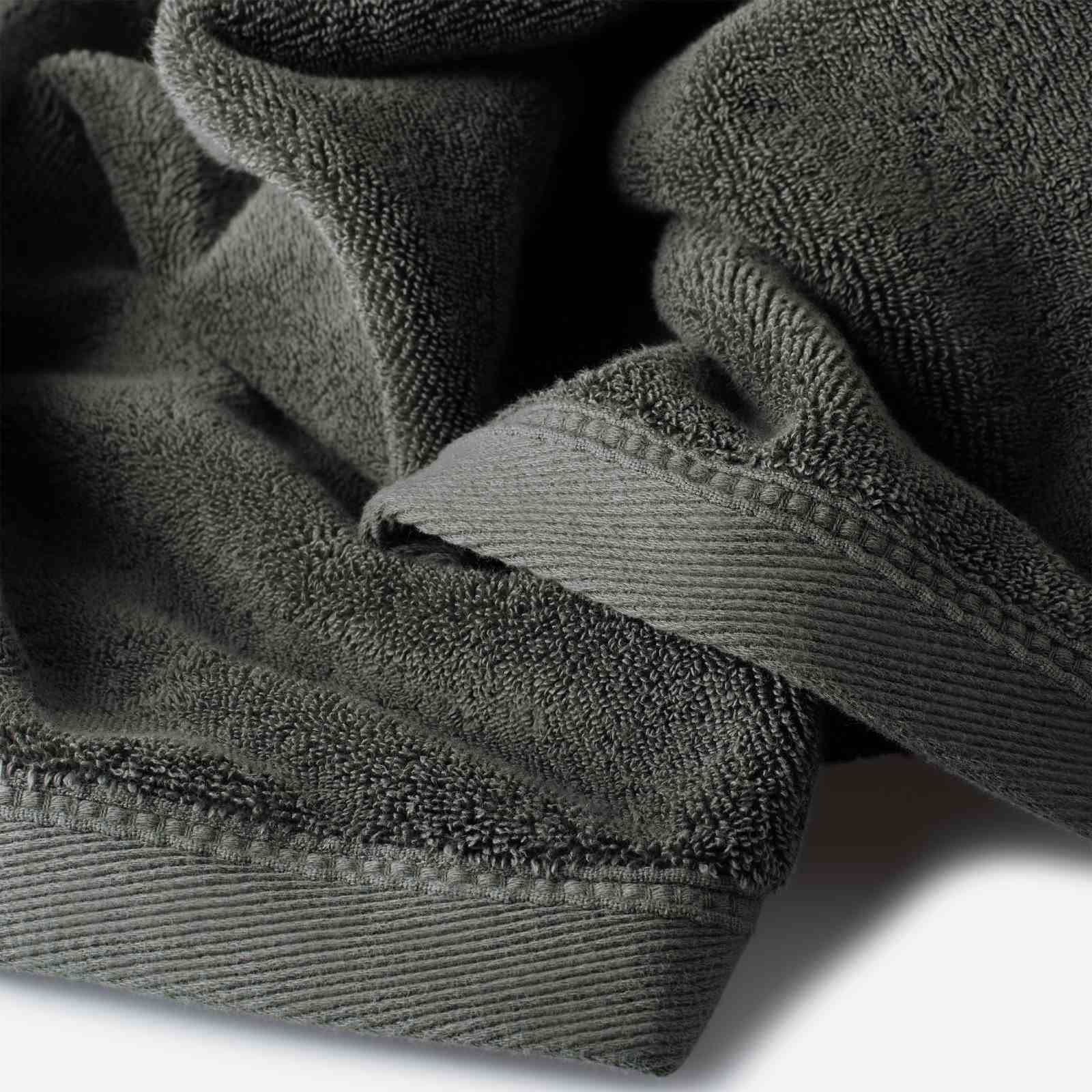 Close-up of a dark olive green cotton towel highlighting the terry texture and ribbed woven border detail.