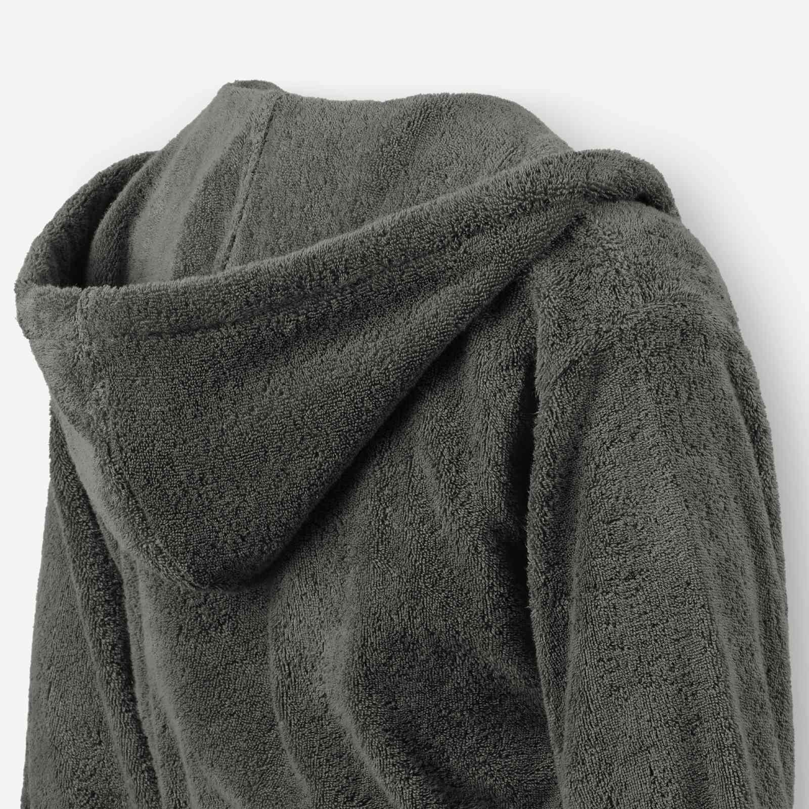 Close-up of a dark grey terry cotton bathrobe showing the hood detail and plush texture.