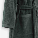 Close-up of a mosstone terry cotton bathrobe showing the waist tie belt, front patch pocket, and sleeve cuff detail.