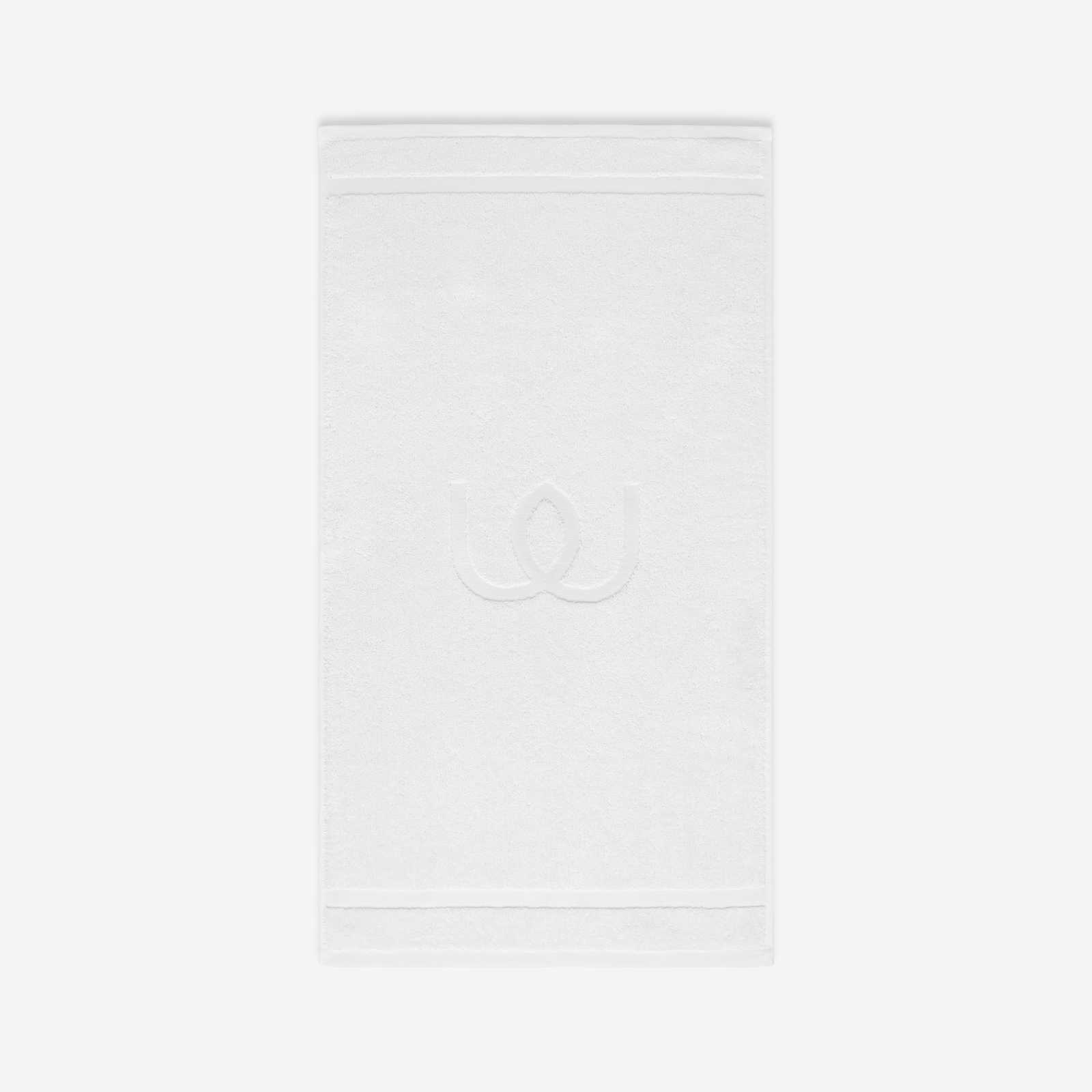 White bath mat with a tonal embroidered logo, shown against a white background.