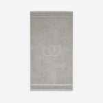 Light gray bath mat with a tonal embroidered logo, shown against a white background.
