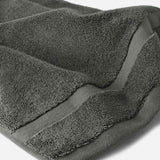 Close-up of a charcoal gray cotton bath sheet highlighting the soft terry texture and woven border detail.