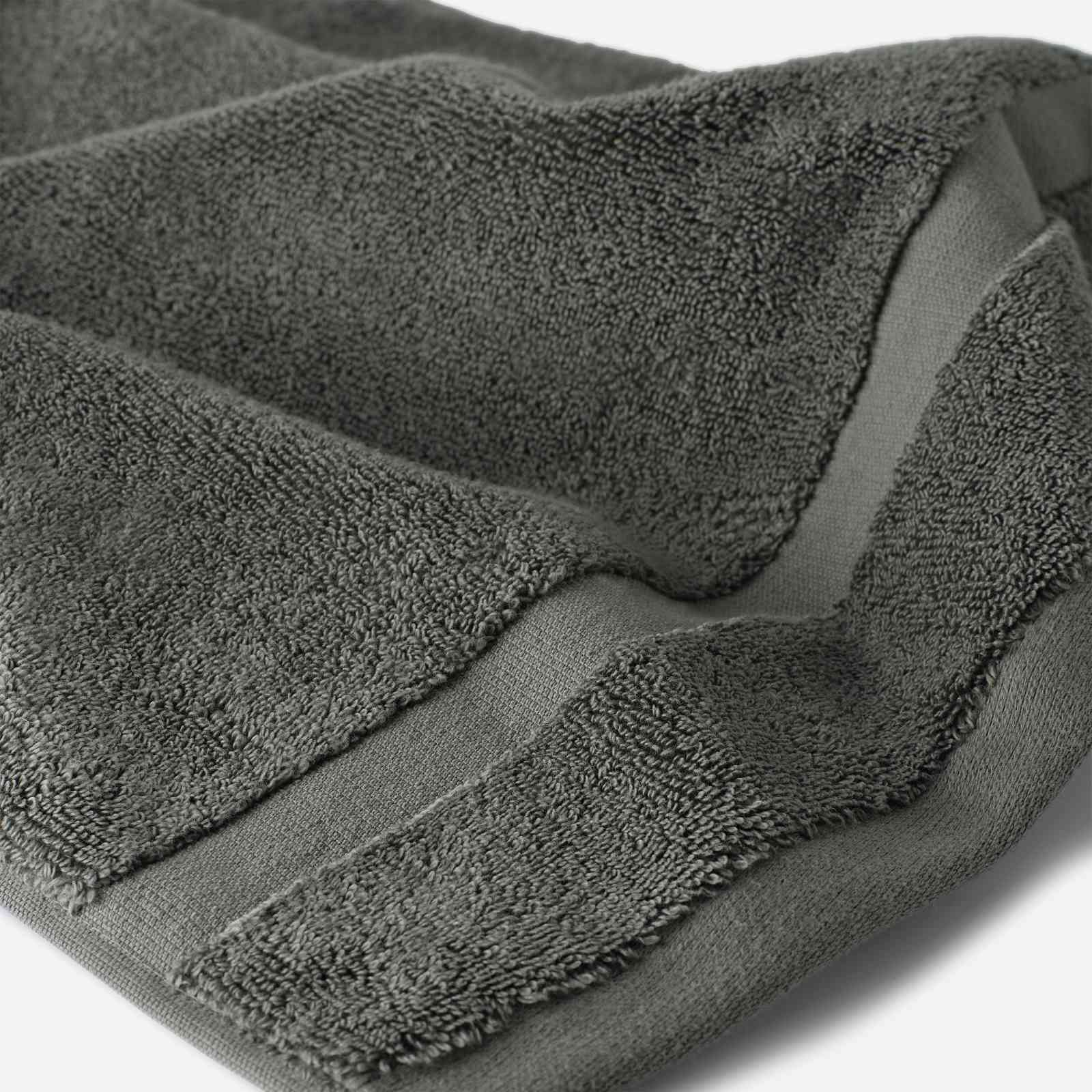 Close-up of a charcoal gray cotton bath sheet highlighting the soft terry texture and woven border detail.