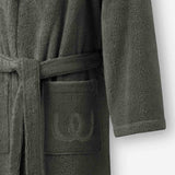 Close-up of a charcoal gray terry cotton bathrobe showing the belt and front pocket with embroidered logo detail.