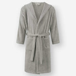 Light gray hooded terry cotton bathrobe with belt and front pockets, shown against a neutral background.
