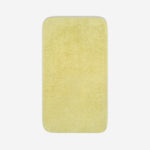 Top view of a yelloe organic cotton towel laid flat with rounded corners, shown on a white background.