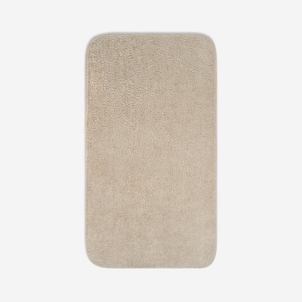 Top view of a beige organic cotton bath sheet with rounded corners, displayed flat on a white background.
