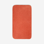Top view of a orange organic cotton bath sheet with rounded corners, displayed flat on a white background.