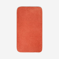 Top view of a orange organic cotton bath sheet with rounded corners, displayed flat on a white background.