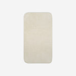 Top view of a light cream cotton bath towel with rounded corners, displayed flat on a white background.