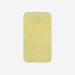 Top view of a yellow organic cotton towel laid flat with rounded corners, shown on a white background.