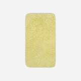 Top view of a yellow organic cotton towel laid flat with rounded corners, shown on a white background.