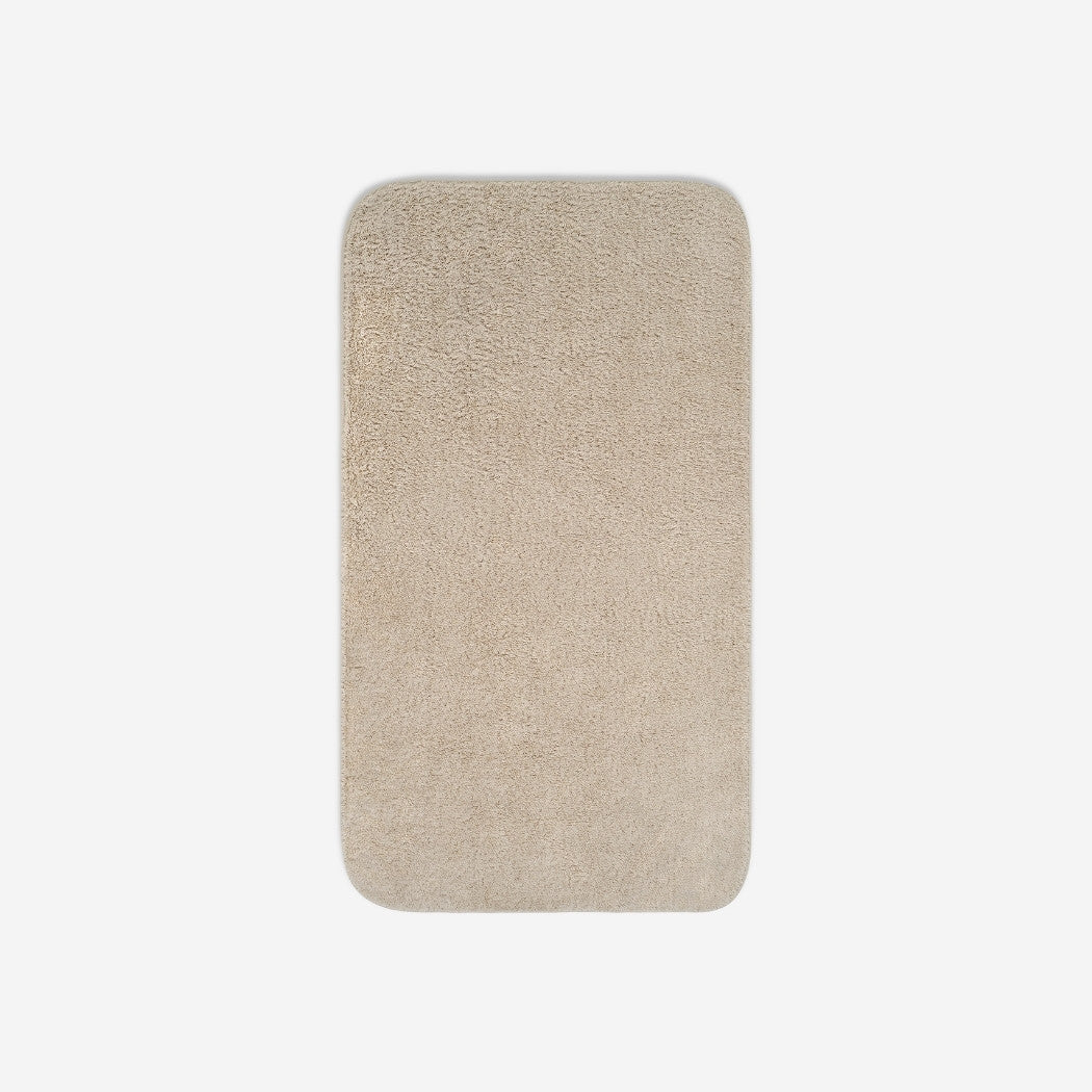 Top view of a beige cotton bath towel with rounded corners, displayed flat on a white background.