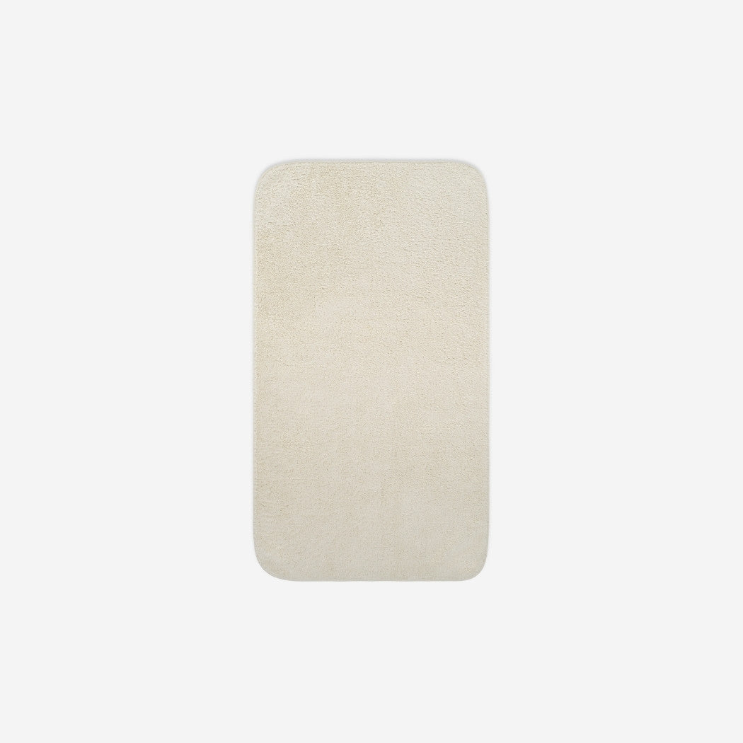 Top view of a beige organic cotton face towel with rounded corners, displayed flat on a white background.