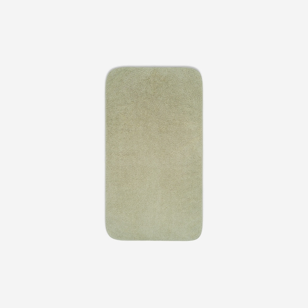 Top view of a light grey organic cotton face towel laid flat with rounded corners, shown on a white background.