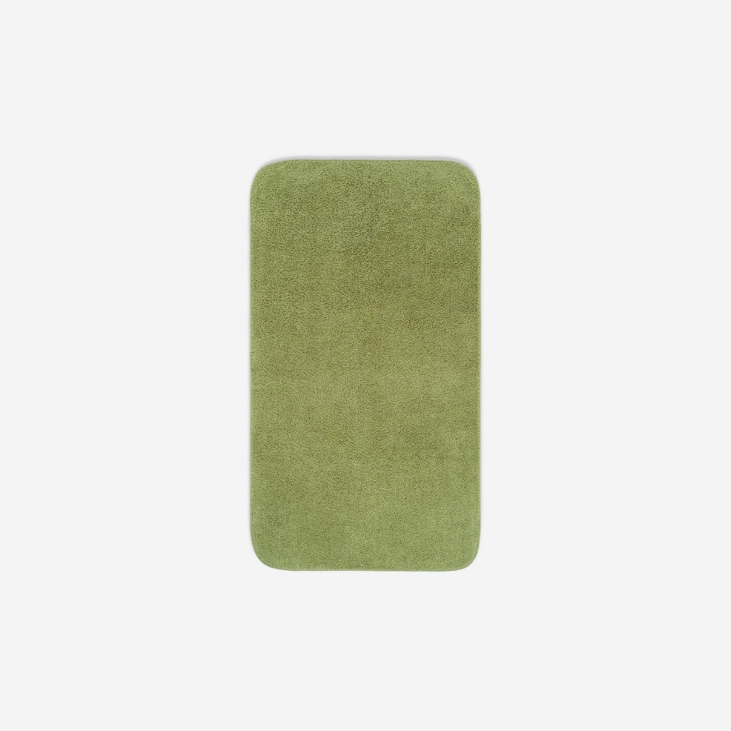 Top view of a green organic cotton face towel laid flat with rounded corners, shown on a white background.