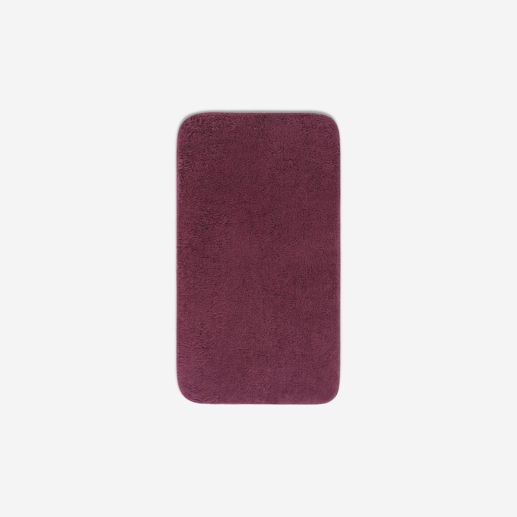 Top view of a purple organic cotton face towel with rounded corners, displayed flat on a white background.
