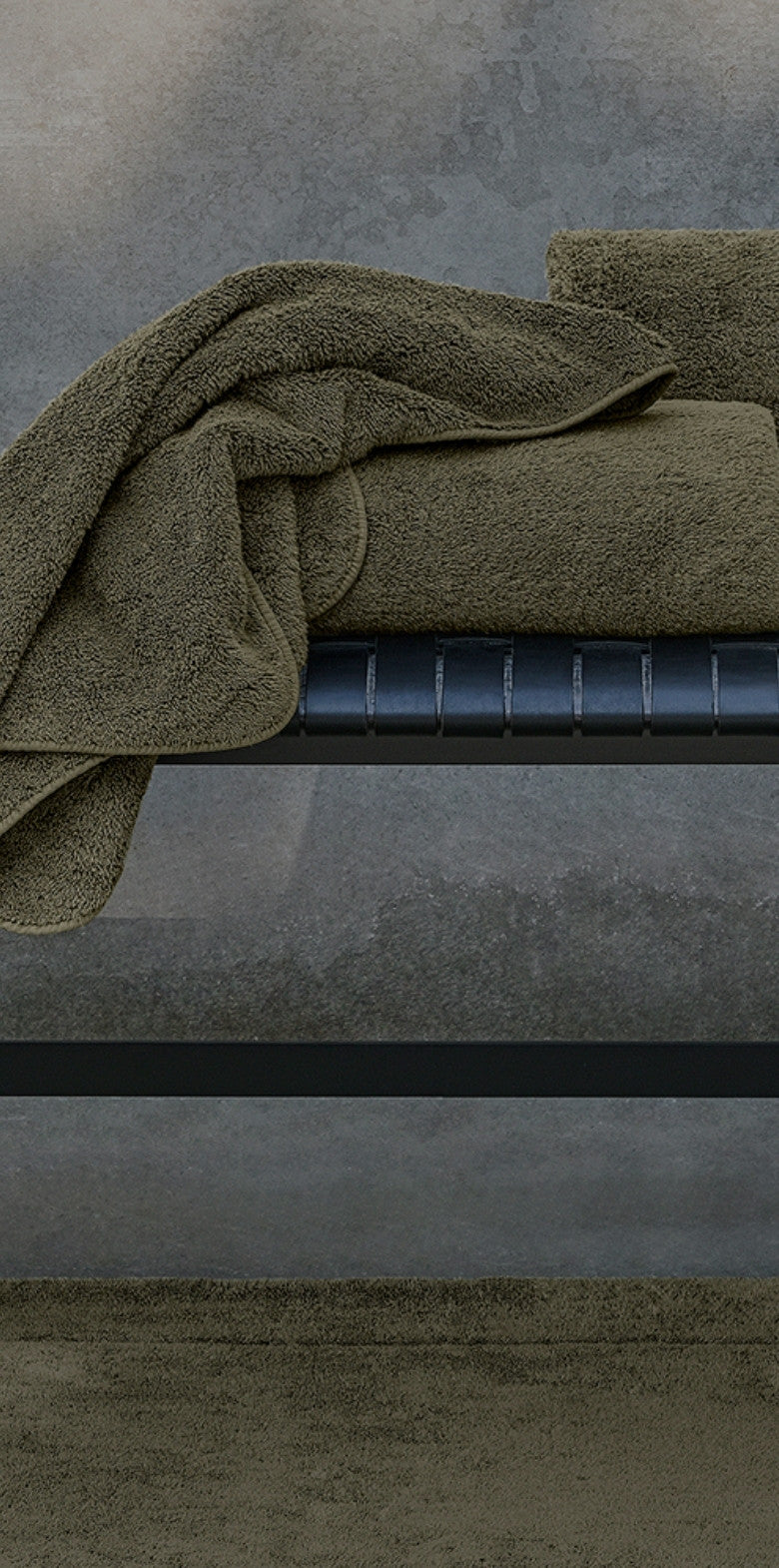 Green towel draped over a gray surface.