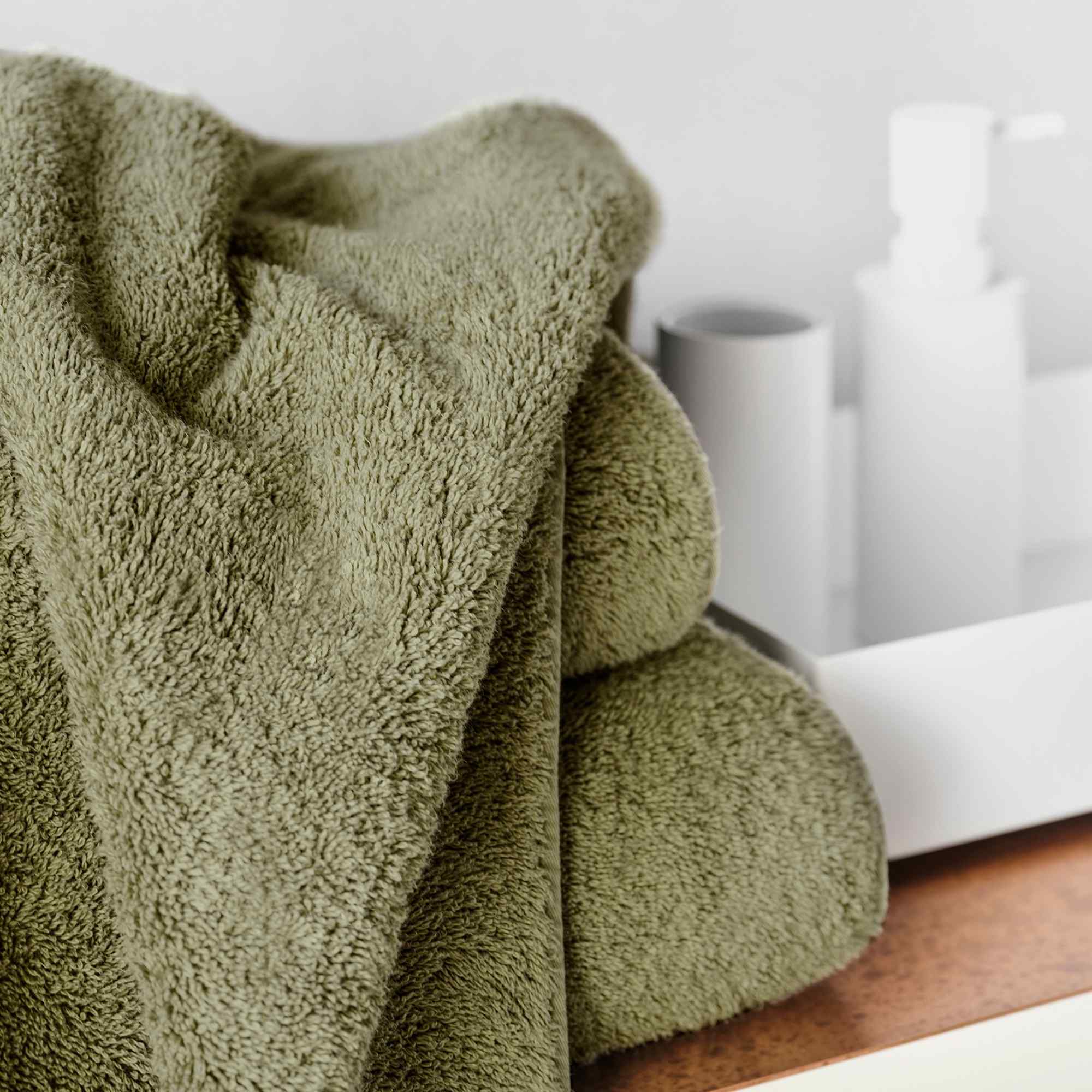 Green towel on a wooden surface with a blurred background.