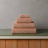 Stack of towels on a green surface with a gray wall background